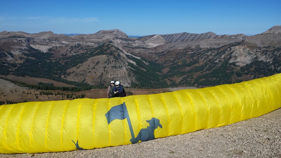 Paraglider sailing above Jackson Hole, Wyoming with blue sky