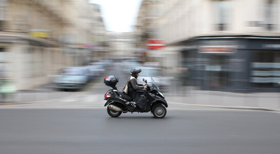 scooter rider in the city traffic in motion blur photo