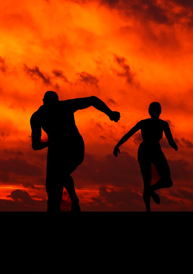 silhouette of two people who play soccer