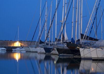 Sailing boats in marina at sunset photo