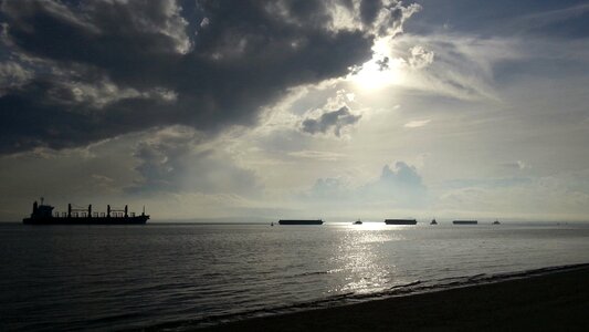 Silhouette of the cargo ship over the sunrise