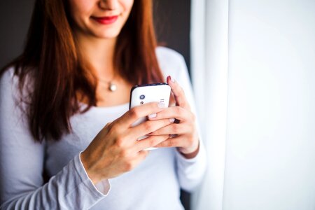 Close up of women's hands holding cell Phone photo
