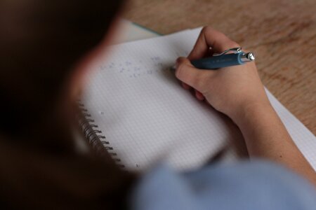 Close-up of a young girl writing into her diary