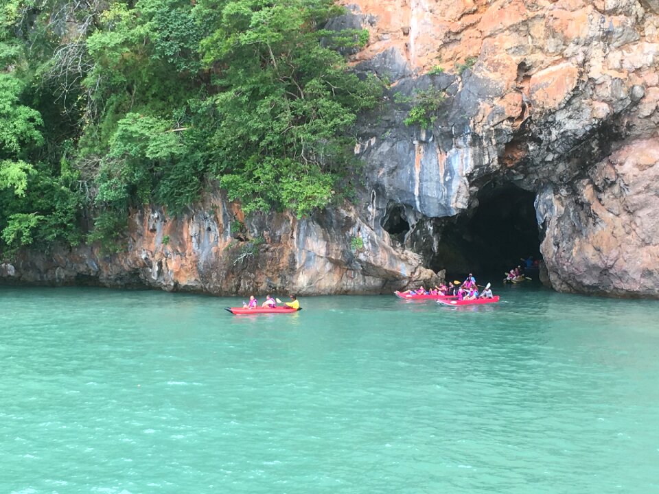 Tourists kayaking through limestone cliffs in Phang-nga Bay