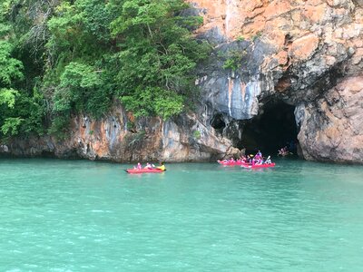 Tourists kayaking through limestone cliffs in Phang-nga Bay photo