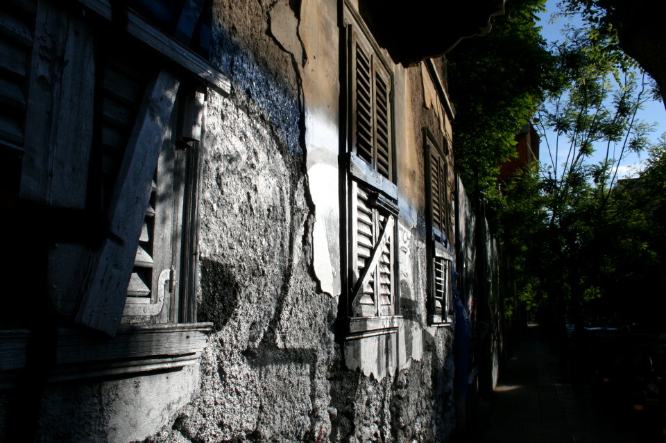 Boarded up old window with peeling paint weathered wall