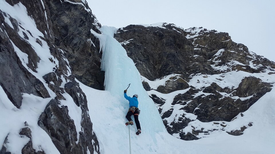 A young climber climbs on ice climbing photo