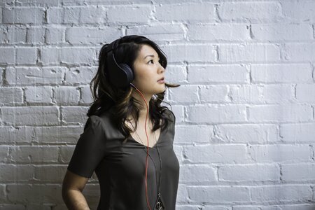 woman wearing black headphones listening to music photo