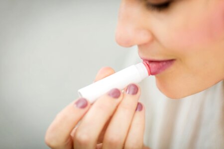 woman applying lip balm photo
