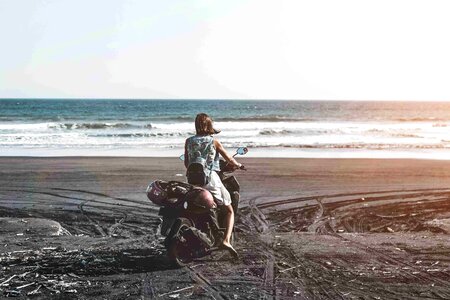 Young woman driving a scooter at the beach
