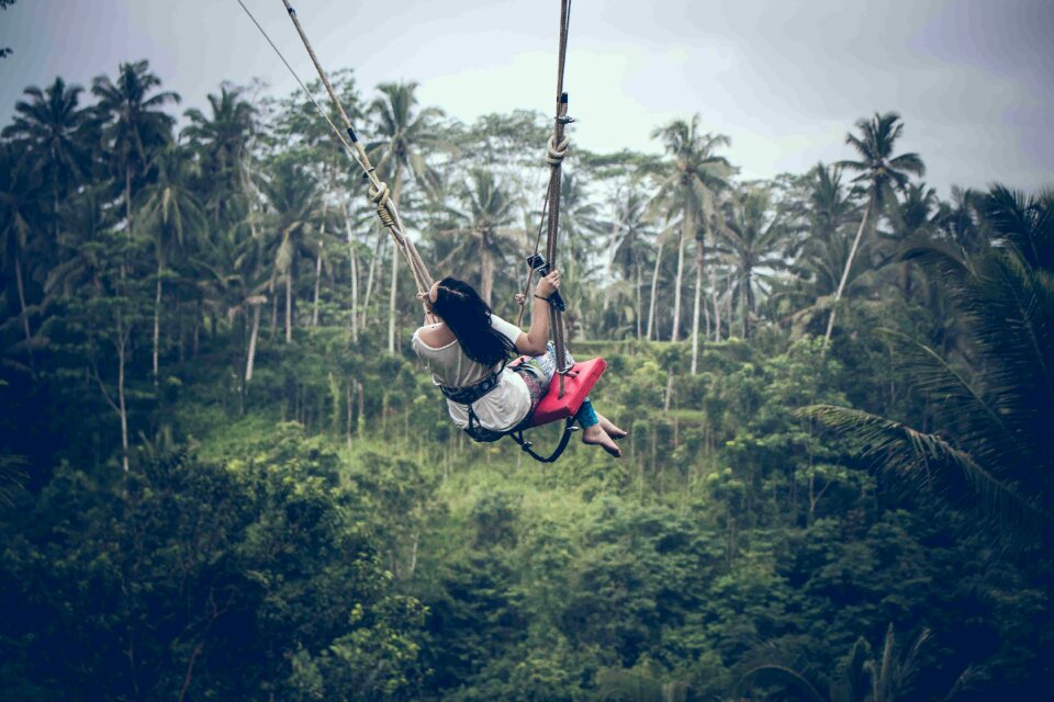 Woman swinging in the jungle of Bali island