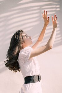 beautiful blond girl covering face by hand of bright sun light