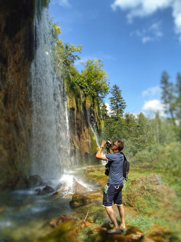 Professional photographer taking photo of waterfall