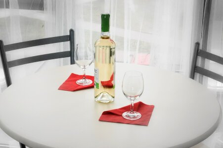 Table setting with empty plate, wine glass and wine bottle photo
