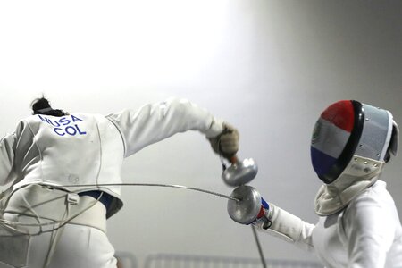 Two Woman fencing athletes fight on professional sports