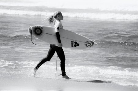 Attractive female surfer with surfboard photo