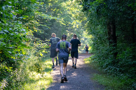 Group of young people trail running on a mountain path photo