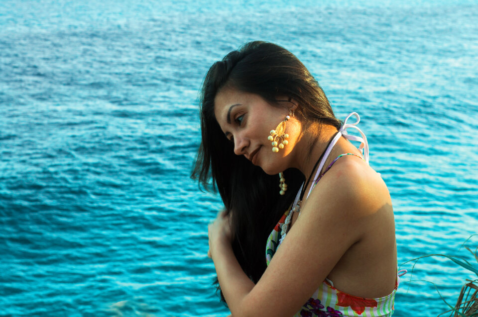 Sexy female sitting on the rock in the sea