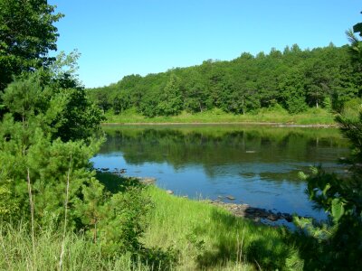 Rocks and woods line the shore of the river near Stevens Creek photo