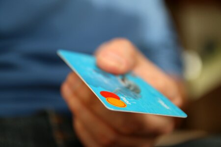 closeup of blue credit card holded by hand. focus on card