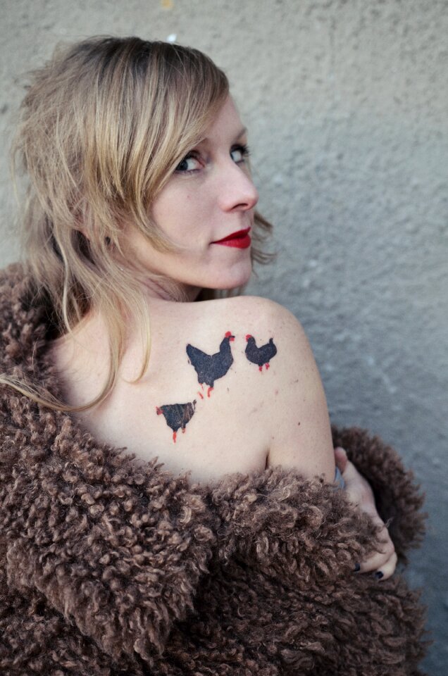 Beautiful woman studio portrait with tattoos on her shoulder.