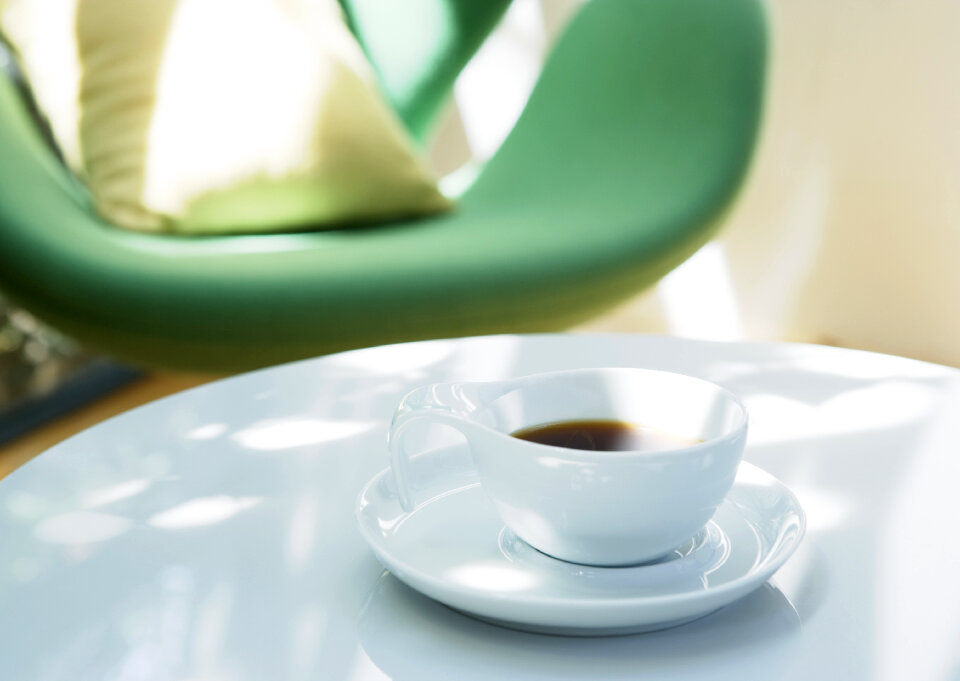 white cup of coffee on white table