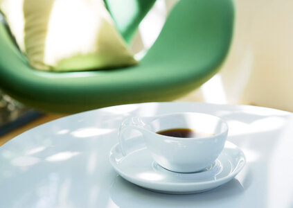 white cup of coffee on white table photo
