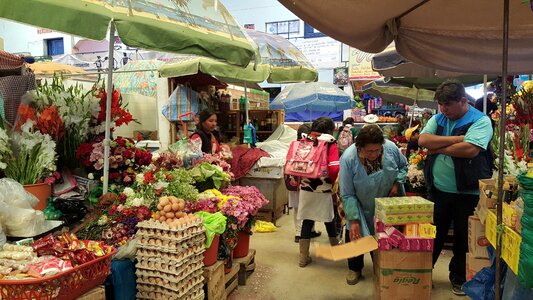 People selling and buying fruits at a market in the steets