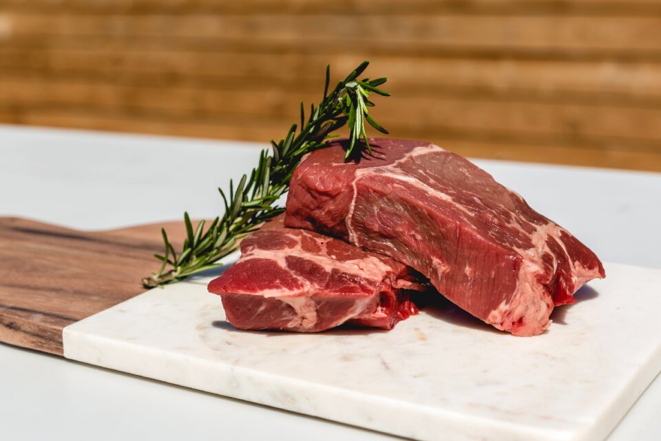 Two well-marbled steaks and some rosemary