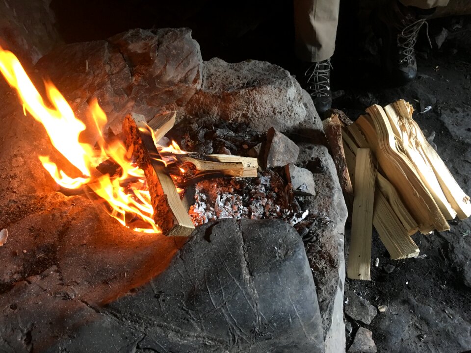 A campfire burns in the night at the tourist shelter