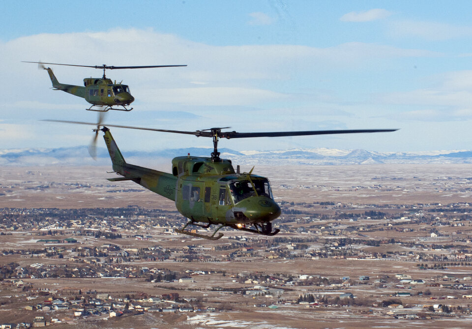Two UH-1N helicopters fly in formation