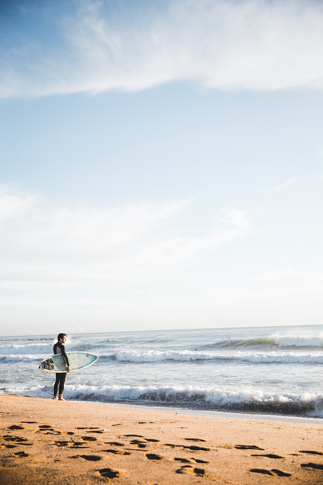 Surfer Standing By Ocean