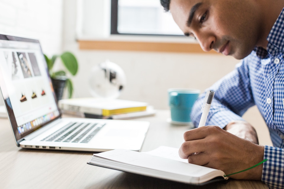 Man Writing In Notebook photo