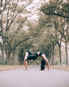 Woman Does Bridge Pose Yoga On Path