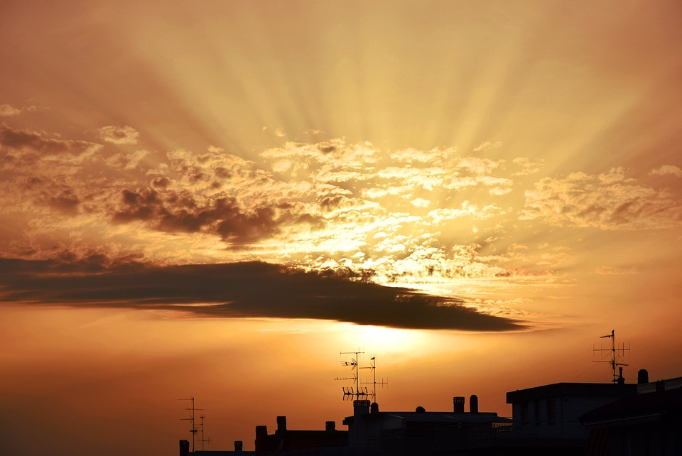 Sunset Over City Rooftops With Antennas