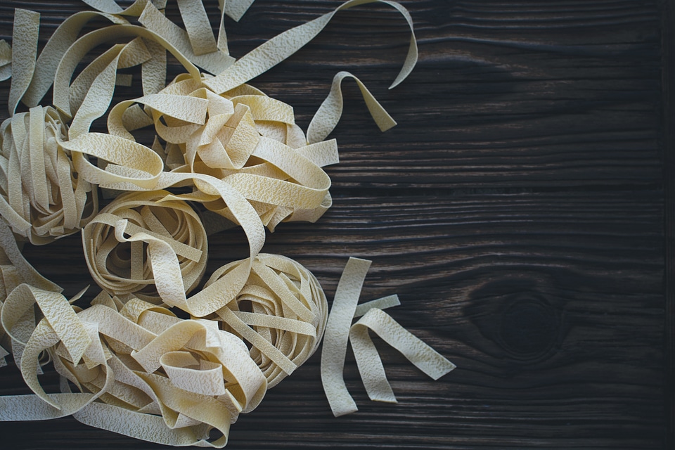 Pasta tagliatelle on a wooden background