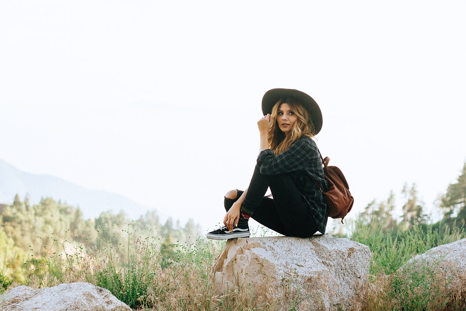 Woman with Backpack Sitting on the Rock