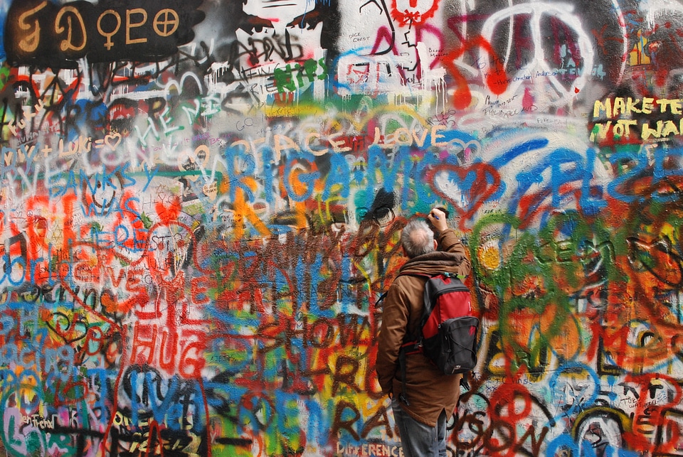 Guy painting on John Lennon wall
