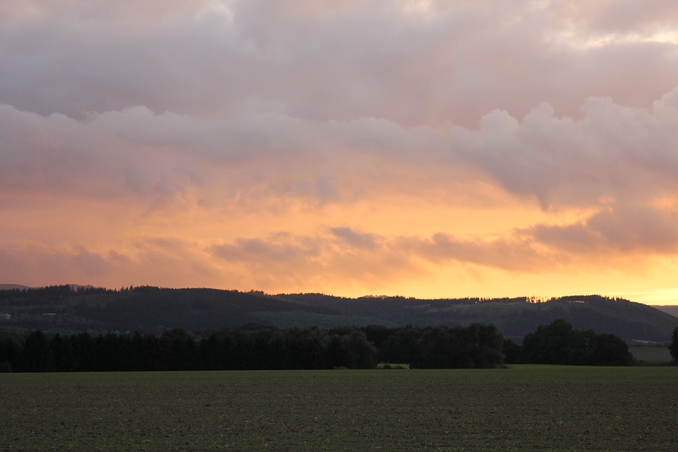 Burning sky over green fields