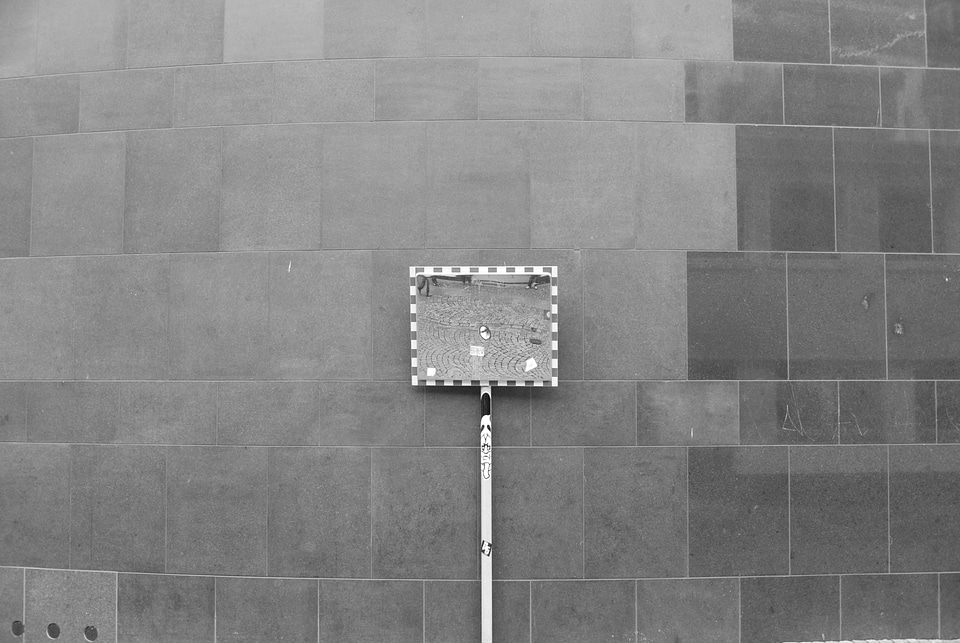 Traffic mirror in front of a big wall