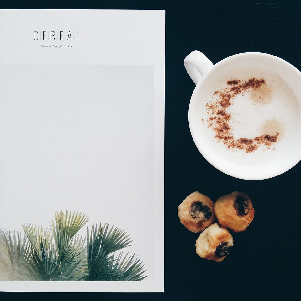 Having cappuccino while reading a magazine