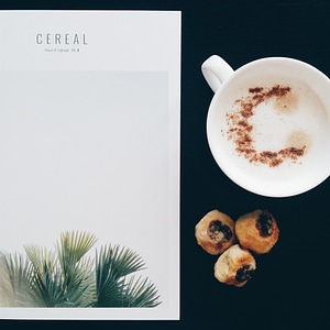 Having cappuccino while reading a magazine