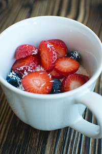 Cup of oatmeal with berries and coconut