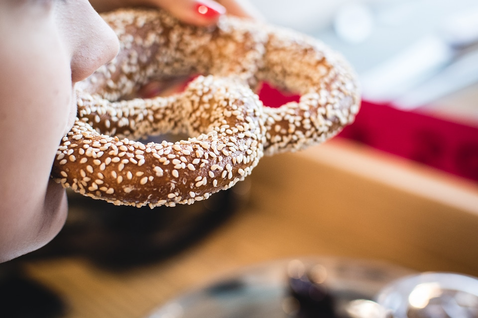 Eating pretzel with sesame seeds