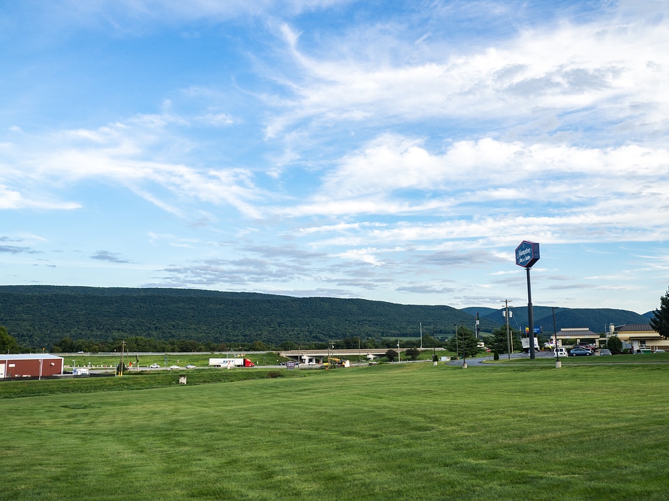 Grass and Mountains Over Blue Sky