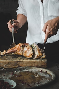 Woman cutting turkey thigh photo