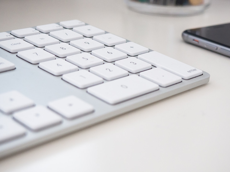 Keyboard and Phone on White Desk