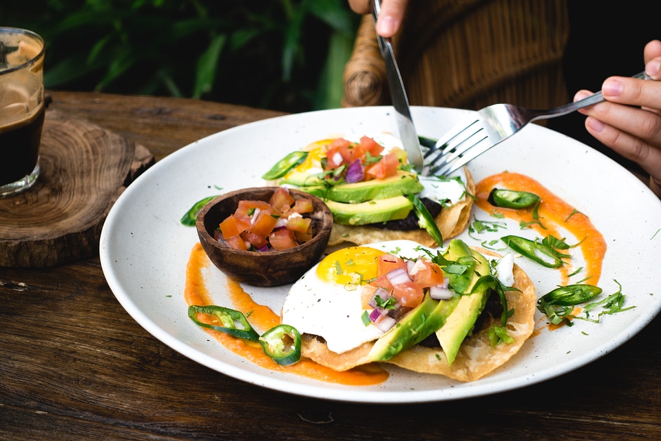 Eating eggs with avocado for breakfast