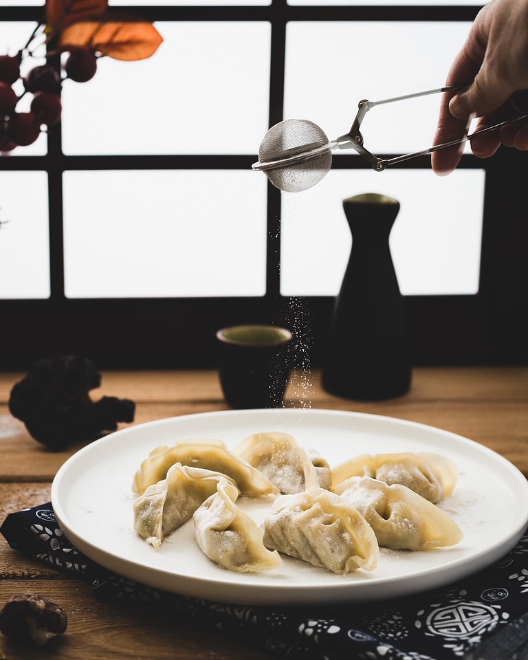 Spreading sugar on sweet fruity dumplings