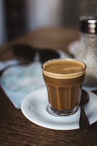 Cortado coffee with a map and sunglasses behind